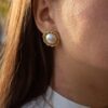 Eterna stud earrings with pearl, handmade brass studs with elegant round design and natural pearl detail. Timeless artisan jewelry, affordable wearable art, unique handmade accessories by Sunny Designs small business. Σκουλαρίκια Eterna καρφωτά με μαργαριτάρι, χειροποίητα σκουλαρίκια από ορείχαλκο με κομψό στρογγυλό σχέδιο και φυσικό μαργαριτάρι. Διαχρονικά κοσμήματα τέχνης, προσιτά χειροποίητα αξεσουάρ, μοναδικά κοσμήματα από τη μικρή επιχείρηση Sunny Designs.