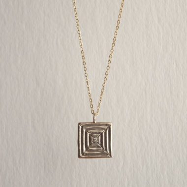Handcrafted concentric circle pendant necklace in gold plated brass with stainless steel chain, affordable bohemian artisan jewelry, modern symbolic accessory, handmade small business design by Sunny Designs