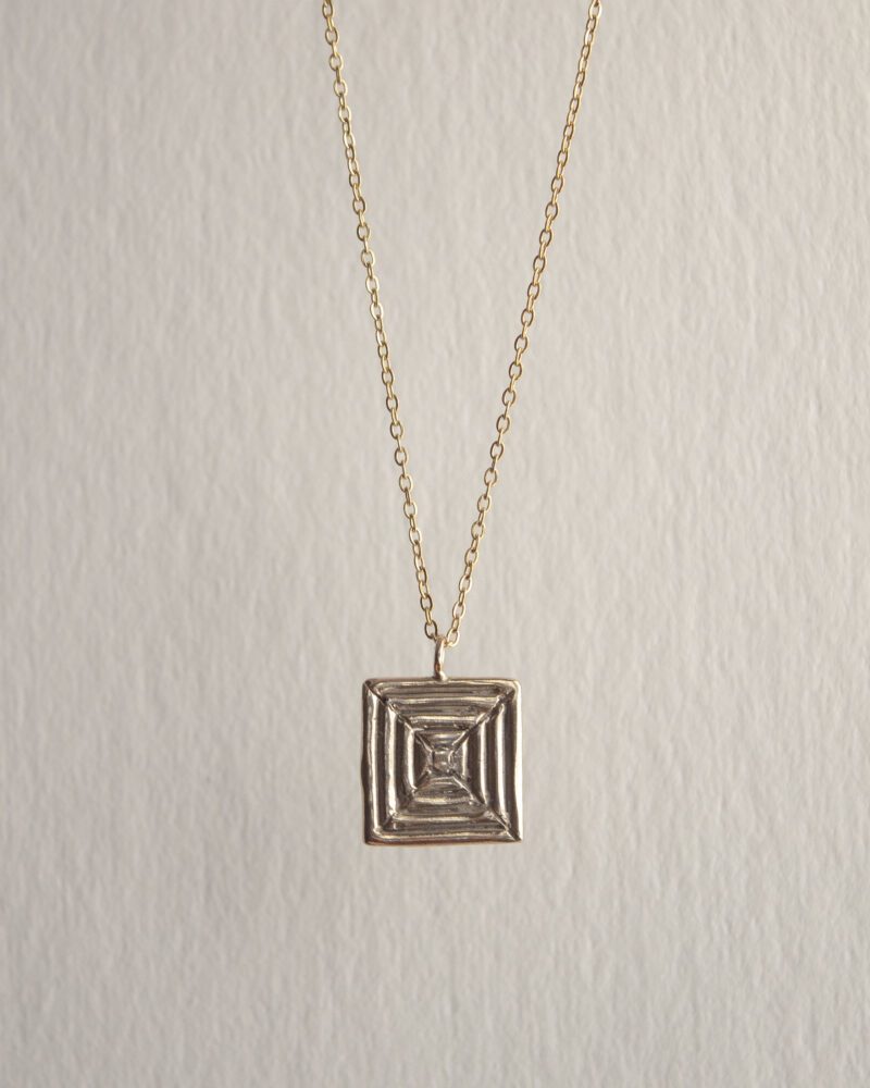Handcrafted concentric circle pendant necklace in gold plated brass with stainless steel chain, affordable bohemian artisan jewelry, modern symbolic accessory, handmade small business design by Sunny Designs