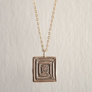 Handcrafted concentric circle pendant necklace in gold plated brass with stainless steel chain, affordable bohemian artisan jewelry, modern symbolic accessory, handmade small business design by Sunny Designs