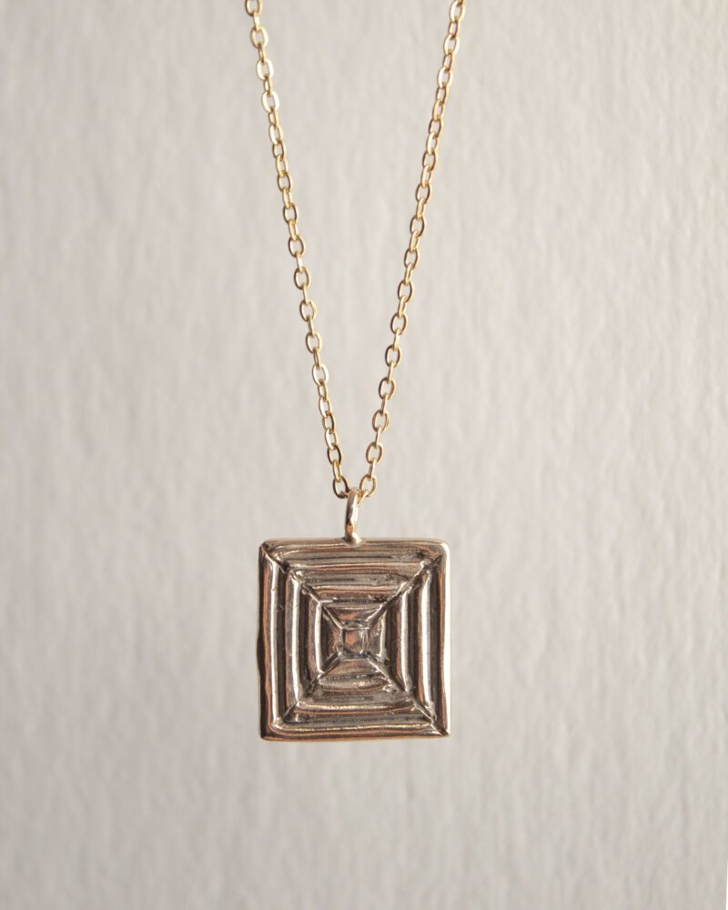 Handcrafted concentric circle pendant necklace in gold plated brass with stainless steel chain, affordable bohemian artisan jewelry, modern symbolic accessory, handmade small business design by Sunny Designs