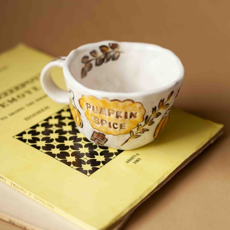 A beautiful ceramic mug that writes pumpkin spice and has on it hot beverages, chocolates , cinammon sticks and total fall vibe. perfect for your coffee. χειροποίητη κεραμική κούπα που γράφει pumpkin spice και έχει πάνω ζωγραφισμένα ροφήματα με σαντιγί , στικ κανέλας, και σοκολάτα. Ιδανική για καφέ.
