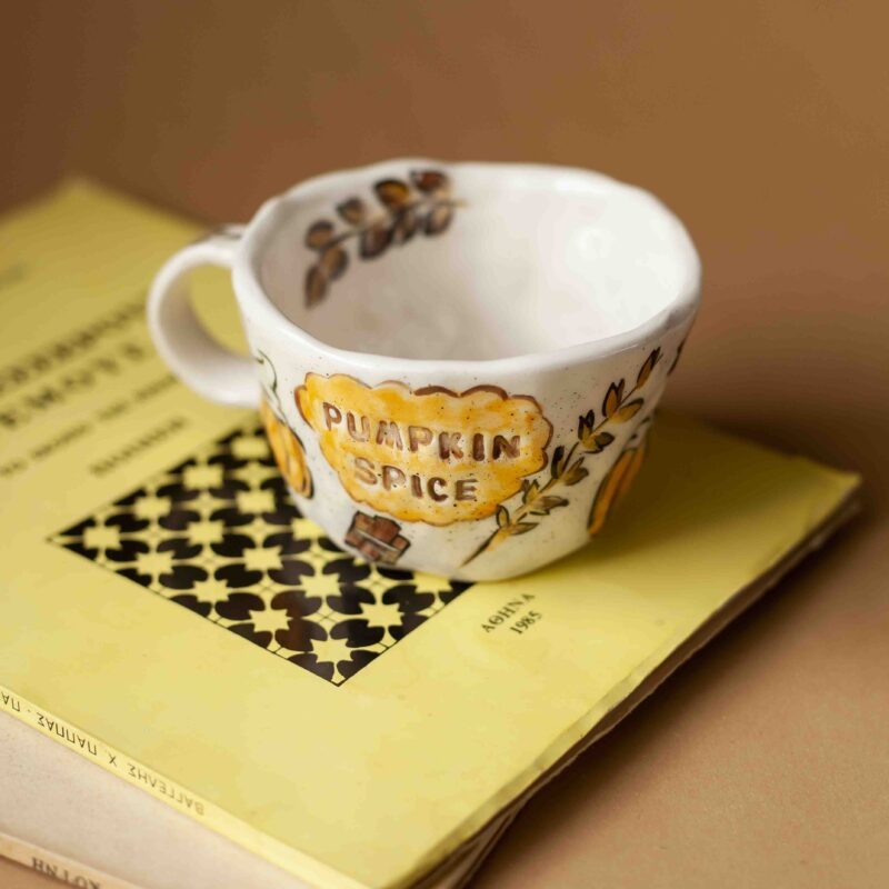 A beautiful ceramic mug that writes pumpkin spice and has on it hot beverages, chocolates , cinammon sticks and total fall vibe. perfect for your coffee. χειροποίητη κεραμική κούπα που γράφει pumpkin spice και έχει πάνω ζωγραφισμένα ροφήματα με σαντιγί , στικ κανέλας, και σοκολάτα. Ιδανική για καφέ.