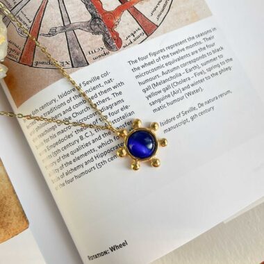 The Starfire Necklace from Sunny Designs features a stunning blue cat’s eye stone set in a brass star pendant. The reflective stone creates a captivating glow, symbolizing intuition and clarity. A perfect piece for elegant, confident styles.