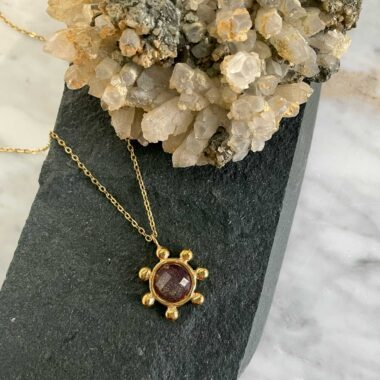 Elegant and mysterious, the Starfire Necklace by Sunny Designs features a dark purple stone that exudes sophistication. Handmade from brass, this pendant embodies balance between strength and serenity. Perfect for those who seek a refined yet artistic look.