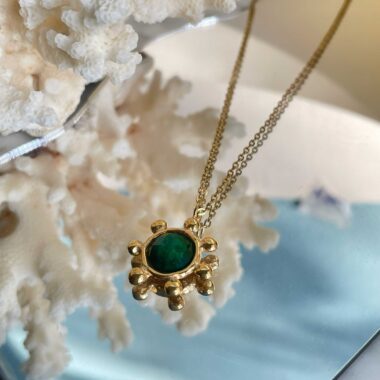 The Starfire Necklace by Sunny Designs celebrates harmony and renewal with its bright green stone centerpiece. Carefully handcrafted from brass, this necklace adds a refreshing pop of color and charm. A versatile accessory that complements both day and evening looks.