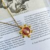 Το Starfire κολιέ της Sunny Designs αποπνέει ουράνια ομορφιά με μενταγιόν σε σχήμα αστεριού και απαλή μωβ πέτρα. Χειροποίητο από ορείχαλκο, προσφέρει γαλήνη, έμπνευση και κομψότητα σε κάθε look.