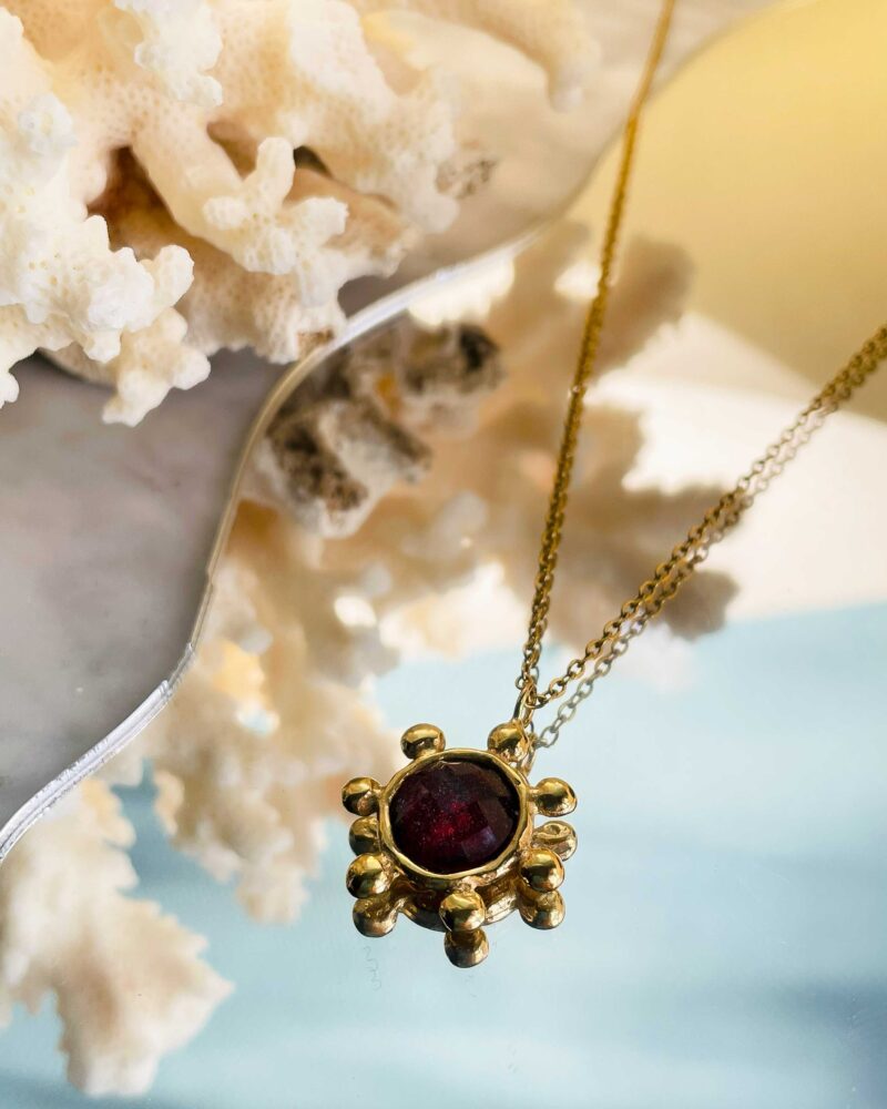 The Starfire Necklace by Sunny Designs radiates passion and confidence with its striking red stone. Handmade from brass, it symbolizes strength, love, and vitality — a perfect statement piece for every occasion.