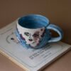 handmade ceramic mug with clouds and faces. an amazing perfect mug with celestial creatures perfect for capuccino and tea. Μια πανέμορφη χειροποίητη κούπα με συννεφάκια με πρόσωπα. Κατάλληλη για καπουτσίνο και τσάι.