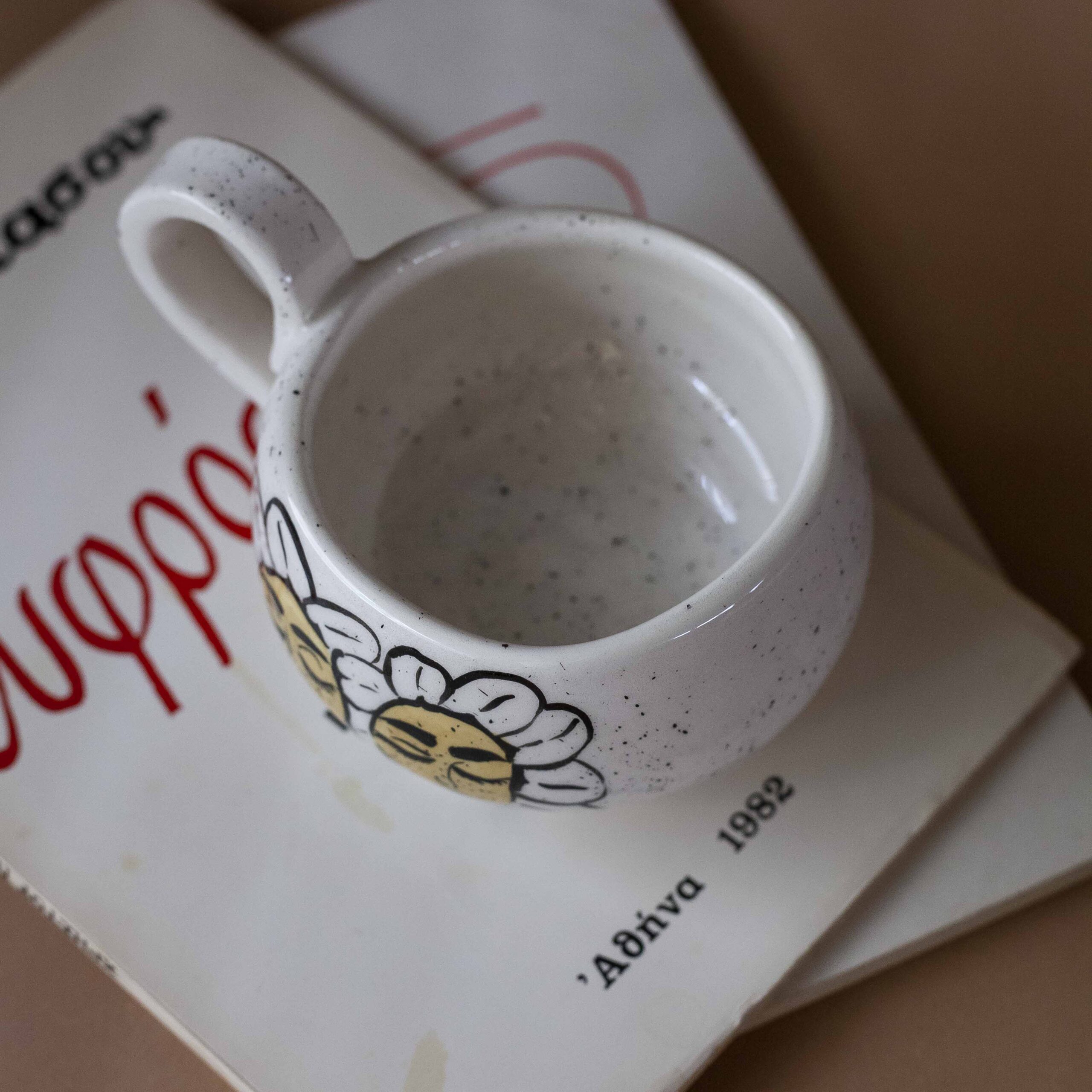 Χειροποίητη κεραμική κούπα διακοσμημένη με ζωγραφιστές μαργαρίτες και πολύχρωμα λουλούδια, όλα με γλυκά προσωπάκια και εκφραστικά μάτια. Πλασμένη και ζωγραφισμένη στο χέρι, κάθε κούπα είναι ένα μοναδικό έργο τέχνης που συνδυάζει τη φρεσκάδα της φύσης με μια παιχνιδιάρικη, ονειρική αισθητική. Ιδανική για όσους αγαπούν τα λουλούδια και τη χειροποίητη δημιουργία. Handmade ceramic mug decorated with painted daisies and colorful flowers, each featuring cute little faces with expressive eyes. Hand-shaped and hand-painted, every mug is a one-of-a-kind piece of art that blends the freshness of nature with a playful, dreamy aesthetic. Perfect for flower lovers and fans of handmade craftsmanship.