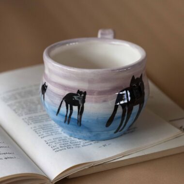 Χειροποίητη κεραμική κούπα με ζωγραφισμένες γάτες σε σουρεαλιστικό στιλ Νταλί, με υπερβολικά μακριά πόδια και ονειρικά χρώματα. Ένα μοναδικό, καλλιτεχνικό κομμάτι που συνδυάζει το χιούμορ με τη φαντασία και τη χειροποίητη λεπτομέρεια. 🇬🇧 Handmade ceramic mug featuring Dali-inspired surreal cats with elongated legs and dreamy colors. A truly unique artistic piece that blends humor, imagination, and handcrafted charm.