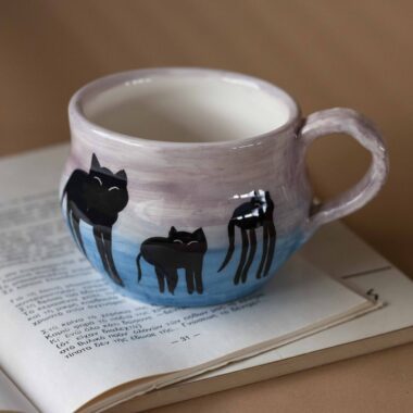 Χειροποίητη κεραμική κούπα με ζωγραφισμένες γάτες σε σουρεαλιστικό στιλ Νταλί, με υπερβολικά μακριά πόδια και ονειρικά χρώματα. Ένα μοναδικό, καλλιτεχνικό κομμάτι που συνδυάζει το χιούμορ με τη φαντασία και τη χειροποίητη λεπτομέρεια. 🇬🇧 Handmade ceramic mug featuring Dali-inspired surreal cats with elongated legs and dreamy colors. A truly unique artistic piece that blends humor, imagination, and handcrafted charm.