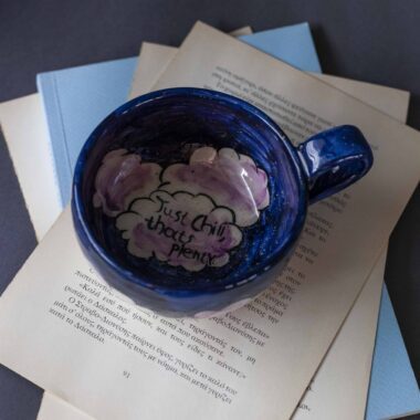Handmade ceramic mug with a cloud-shaped handle and painted cloud faces featuring shiny eyes in an angelic core aesthetic. Soft blue and pink tones create a dreamy, sweet atmosphere. Each mug is one of a kind — hand-shaped and hand-painted, a small personal piece of art for those who love unique creations. Χειροποίητη κεραμική κούπα με χερούλι σε σχήμα συννεφιού και ζωγραφιστά συννεφάκια με εκφραστικά προσωπάκια και γυαλιστερά μάτια σε angelic core αισθητική. Οι απαλοί τόνοι του γαλάζιου και του ροζ προσδίδουν μια ονειρική, γλυκιά αίσθηση. Κάθε κούπα είναι μοναδική, πλασμένη και ζωγραφισμένη στο χέρι, ένα μικρό προσωπικό έργο τέχνης για κάθε λάτρη των ιδιαίτερων αντικειμένων.