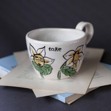 Χειροποίητη κεραμική κούπα διακοσμημένη με ζωγραφιστές μαργαρίτες και πολύχρωμα λουλούδια, όλα με γλυκά προσωπάκια και εκφραστικά μάτια. Πλασμένη και ζωγραφισμένη στο χέρι, κάθε κούπα είναι ένα μοναδικό έργο τέχνης που συνδυάζει τη φρεσκάδα της φύσης με μια παιχνιδιάρικη, ονειρική αισθητική. Ιδανική για όσους αγαπούν τα λουλούδια και τη χειροποίητη δημιουργία. Handmade ceramic mug decorated with painted daisies and colorful flowers, each featuring cute little faces with expressive eyes. Hand-shaped and hand-painted, every mug is a one-of-a-kind piece of art that blends the freshness of nature with a playful, dreamy aesthetic. Perfect for flower lovers and fans of handmade craftsmanship.