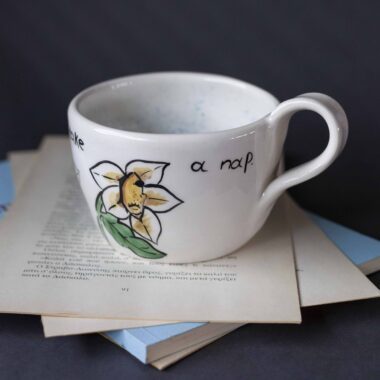 Χειροποίητη κεραμική κούπα διακοσμημένη με ζωγραφιστές μαργαρίτες και πολύχρωμα λουλούδια, όλα με γλυκά προσωπάκια και εκφραστικά μάτια. Πλασμένη και ζωγραφισμένη στο χέρι, κάθε κούπα είναι ένα μοναδικό έργο τέχνης που συνδυάζει τη φρεσκάδα της φύσης με μια παιχνιδιάρικη, ονειρική αισθητική. Ιδανική για όσους αγαπούν τα λουλούδια και τη χειροποίητη δημιουργία. Handmade ceramic mug decorated with painted daisies and colorful flowers, each featuring cute little faces with expressive eyes. Hand-shaped and hand-painted, every mug is a one-of-a-kind piece of art that blends the freshness of nature with a playful, dreamy aesthetic. Perfect for flower lovers and fans of handmade craftsmanship.