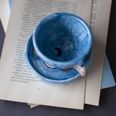 Handmade ceramic mug with a cloud-shaped handle and painted cloud faces featuring shiny eyes in an angelic core aesthetic. Soft blue and pink tones create a dreamy, sweet atmosphere. Each mug is one of a kind — hand-shaped and hand-painted, a small personal piece of art for those who love unique creations. Χειροποίητη κεραμική κούπα με χερούλι σε σχήμα συννεφιού και ζωγραφιστά συννεφάκια με εκφραστικά προσωπάκια και γυαλιστερά μάτια σε angelic core αισθητική. Οι απαλοί τόνοι του γαλάζιου και του ροζ προσδίδουν μια ονειρική, γλυκιά αίσθηση. Κάθε κούπα είναι μοναδική, πλασμένη και ζωγραφισμένη στο χέρι, ένα μικρό προσωπικό έργο τέχνης για κάθε λάτρη των ιδιαίτερων αντικειμένων.