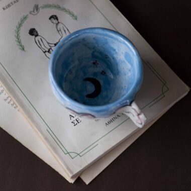 Handmade ceramic mug with a cloud-shaped handle and painted cloud faces featuring shiny eyes in an angelic core aesthetic. Soft blue and pink tones create a dreamy, sweet atmosphere. Each mug is one of a kind — hand-shaped and hand-painted, a small personal piece of art for those who love unique creations. Χειροποίητη κεραμική κούπα με χερούλι σε σχήμα συννεφιού και ζωγραφιστά συννεφάκια με εκφραστικά προσωπάκια και γυαλιστερά μάτια σε angelic core αισθητική. Οι απαλοί τόνοι του γαλάζιου και του ροζ προσδίδουν μια ονειρική, γλυκιά αίσθηση. Κάθε κούπα είναι μοναδική, πλασμένη και ζωγραφισμένη στο χέρι, ένα μικρό προσωπικό έργο τέχνης για κάθε λάτρη των ιδιαίτερων αντικειμένων.