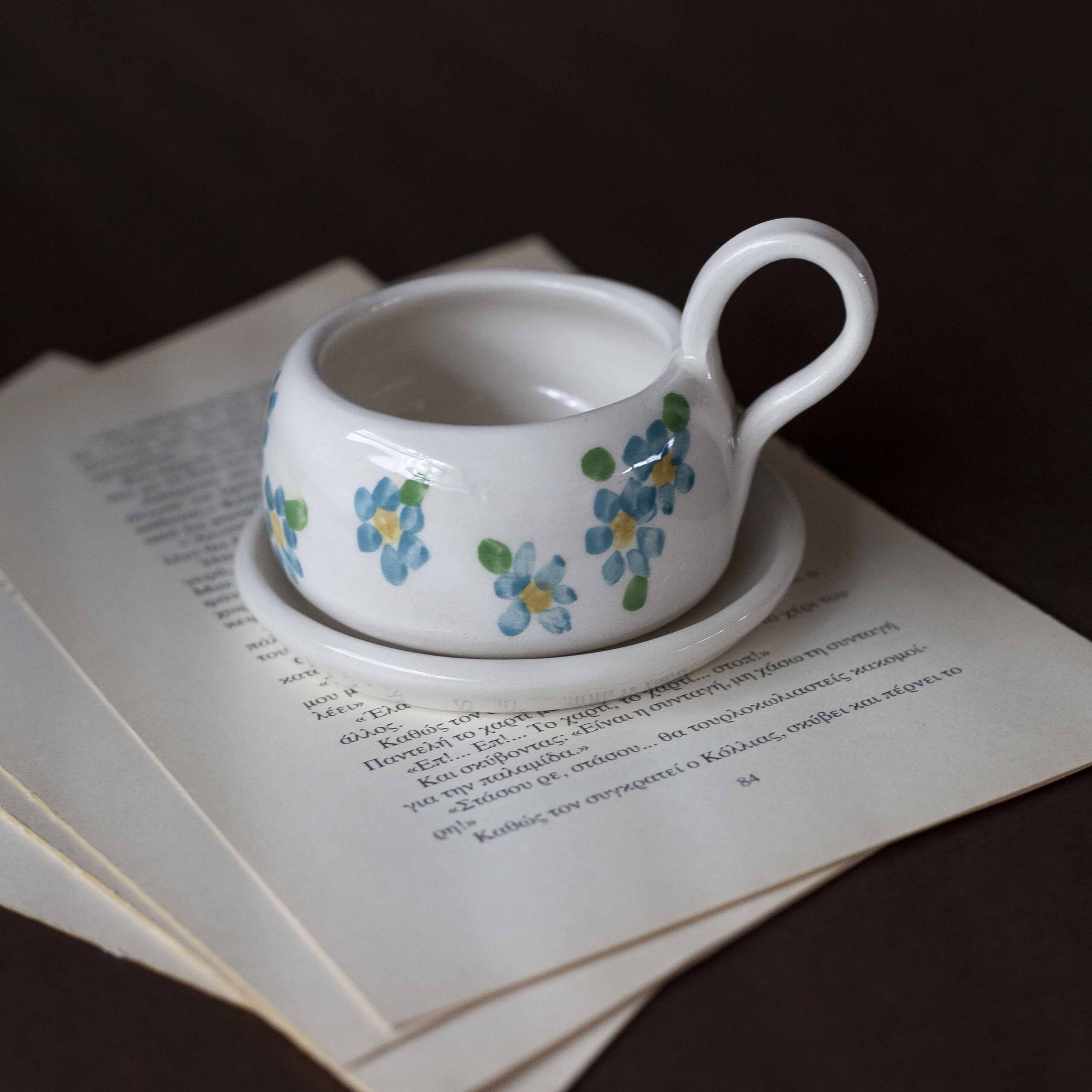 Χειροποίητα κεραμικά εσπρέσο κουπάκια με πιατάκι, διακοσμημένα με ζωγραφιστά φρουτάκια — πορτοκάλια, λεμόνια και αχλάδια — ανάμεσα σε μικρά λουλουδάκια. Οι δίχρωμοι συνδυασμοί και οι λεπτομέρειες στο χέρι χαρίζουν παιχνιδιάρικη και ζωντανή αισθητική. Κάθε σετ είναι μοναδικό, πλασμένο και ζωγραφισμένο στο χέρι, ιδανικό για να προσθέσει χρώμα και τέχνη σε κάθε στιγμή καφέ. Handmade ceramic espresso cup and saucer set, decorated with hand-painted fruits — oranges, lemons, and pears — surrounded by small flowers. The two-tone color combinations and fine hand-painted details give a lively, playful feel. Each set is one of a kind, crafted and painted by hand, perfect for adding a splash of color and artistry to your coffee moments.