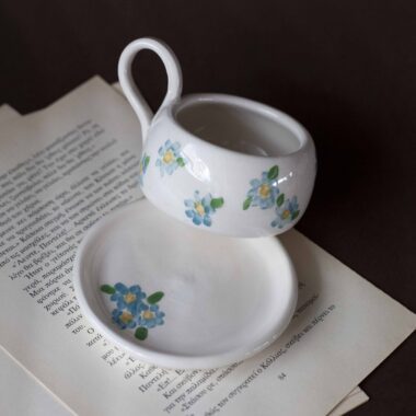 Χειροποίητα κεραμικά εσπρέσο κουπάκια με πιατάκι, διακοσμημένα με ζωγραφιστά φρουτάκια — πορτοκάλια, λεμόνια και αχλάδια — ανάμεσα σε μικρά λουλουδάκια. Οι δίχρωμοι συνδυασμοί και οι λεπτομέρειες στο χέρι χαρίζουν παιχνιδιάρικη και ζωντανή αισθητική. Κάθε σετ είναι μοναδικό, πλασμένο και ζωγραφισμένο στο χέρι, ιδανικό για να προσθέσει χρώμα και τέχνη σε κάθε στιγμή καφέ. Handmade ceramic espresso cup and saucer set, decorated with hand-painted fruits — oranges, lemons, and pears — surrounded by small flowers. The two-tone color combinations and fine hand-painted details give a lively, playful feel. Each set is one of a kind, crafted and painted by hand, perfect for adding a splash of color and artistry to your coffee moments.