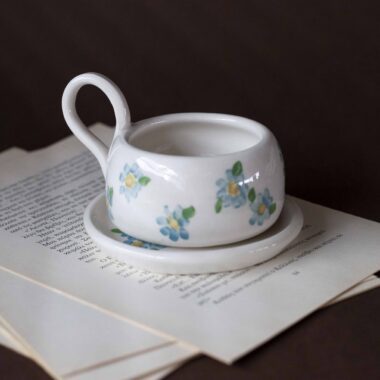 Χειροποίητα κεραμικά εσπρέσο κουπάκια με πιατάκι, διακοσμημένα με ζωγραφιστά φρουτάκια — πορτοκάλια, λεμόνια και αχλάδια — ανάμεσα σε μικρά λουλουδάκια. Οι δίχρωμοι συνδυασμοί και οι λεπτομέρειες στο χέρι χαρίζουν παιχνιδιάρικη και ζωντανή αισθητική. Κάθε σετ είναι μοναδικό, πλασμένο και ζωγραφισμένο στο χέρι, ιδανικό για να προσθέσει χρώμα και τέχνη σε κάθε στιγμή καφέ. Handmade ceramic espresso cup and saucer set, decorated with hand-painted fruits — oranges, lemons, and pears — surrounded by small flowers. The two-tone color combinations and fine hand-painted details give a lively, playful feel. Each set is one of a kind, crafted and painted by hand, perfect for adding a splash of color and artistry to your coffee moments.