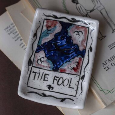 Χειροποίητα κεραμικά δισκάκια εμπνευσμένα από τα σύμβολα των καρτών ταρώ, ζωγραφισμένα στο χέρι με μυστικιστικά σχέδια και χρυσές λεπτομέρειες. Κάθε δίσκος είναι μοναδικός, ιδανικός για κοσμήματα, κρυστάλλους ή διακόσμηση με μαγική αισθητική. Handmade ceramic tarot-inspired trays, hand-painted with mystical symbols and golden details. Each piece is unique, perfect for holding jewelry, crystals, or simply adding a touch of magic to your decor.