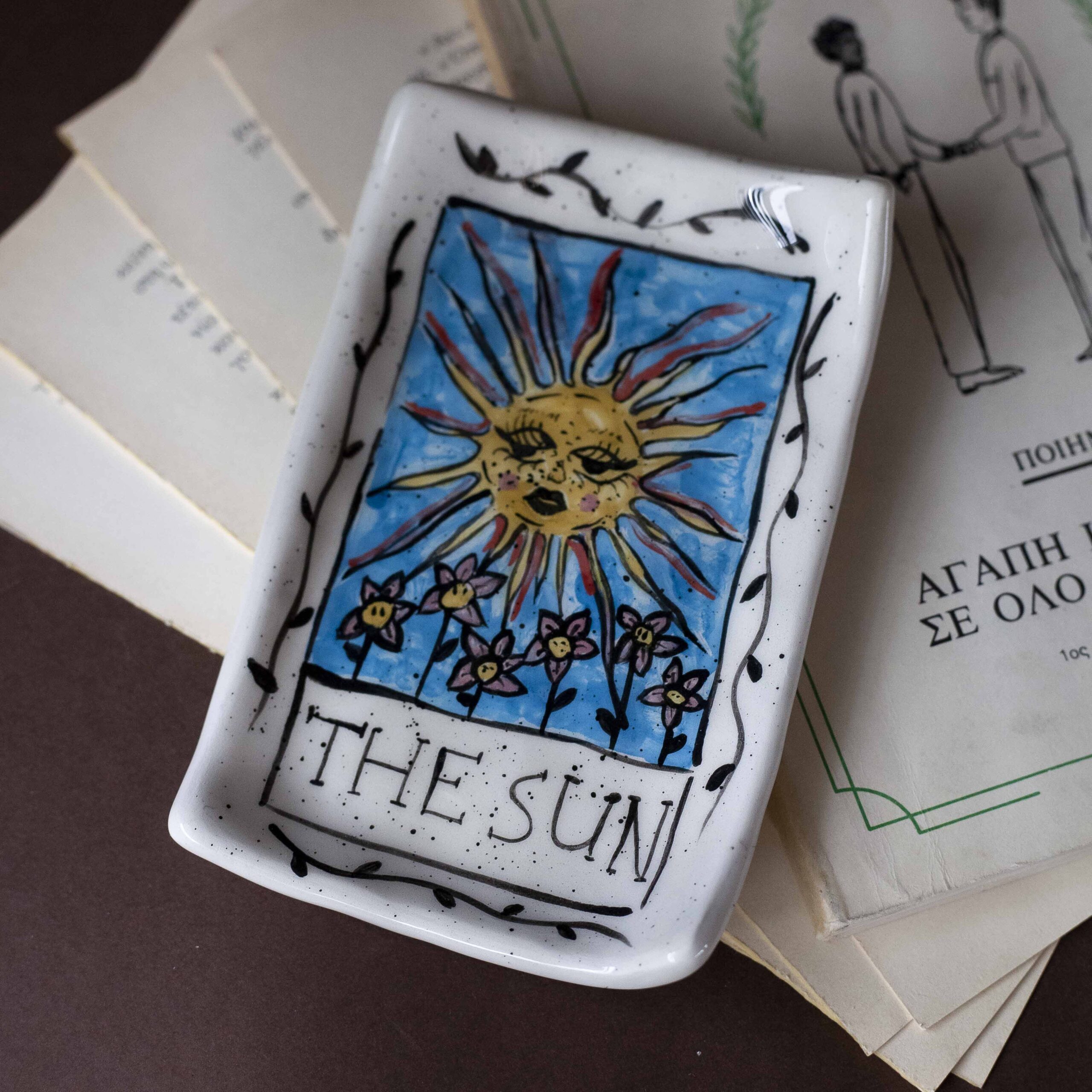 Χειροποίητα κεραμικά δισκάκια εμπνευσμένα από τα σύμβολα των καρτών ταρώ, ζωγραφισμένα στο χέρι με μυστικιστικά σχέδια και χρυσές λεπτομέρειες. Κάθε δίσκος είναι μοναδικός, ιδανικός για κοσμήματα, κρυστάλλους ή διακόσμηση με μαγική αισθητική. Handmade ceramic tarot-inspired trays, hand-painted with mystical symbols and golden details. Each piece is unique, perfect for holding jewelry, crystals, or simply adding a touch of magic to your decor.