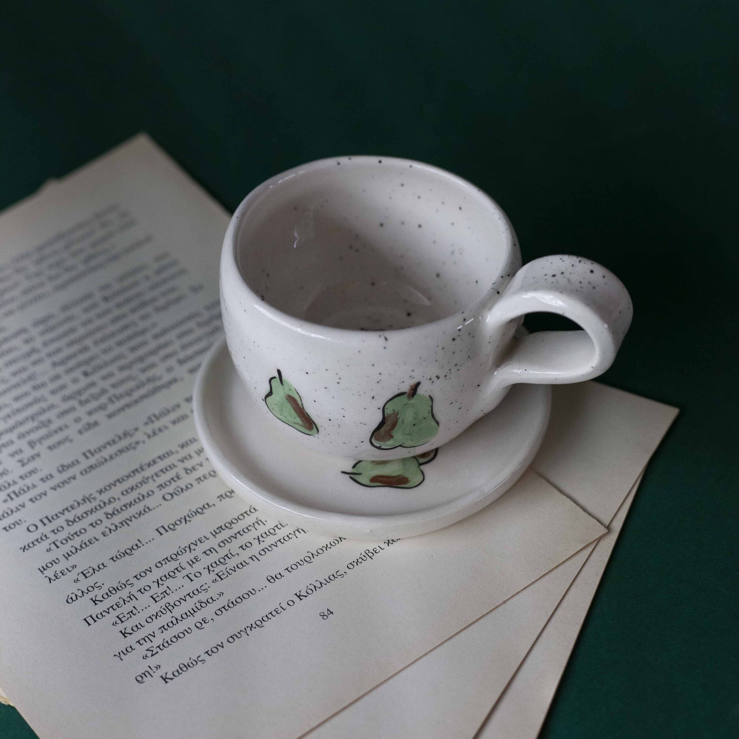 Χειροποίητα κεραμικά εσπρέσο κουπάκια με πιατάκι, διακοσμημένα με ζωγραφιστά φρουτάκια — πορτοκάλια, λεμόνια και αχλάδια — ανάμεσα σε μικρά λουλουδάκια. Οι δίχρωμοι συνδυασμοί και οι λεπτομέρειες στο χέρι χαρίζουν παιχνιδιάρικη και ζωντανή αισθητική. Κάθε σετ είναι μοναδικό, πλασμένο και ζωγραφισμένο στο χέρι, ιδανικό για να προσθέσει χρώμα και τέχνη σε κάθε στιγμή καφέ. Handmade ceramic espresso cup and saucer set, decorated with hand-painted fruits — oranges, lemons, and pears — surrounded by small flowers. The two-tone color combinations and fine hand-painted details give a lively, playful feel. Each set is one of a kind, crafted and painted by hand, perfect for adding a splash of color and artistry to your coffee moments.