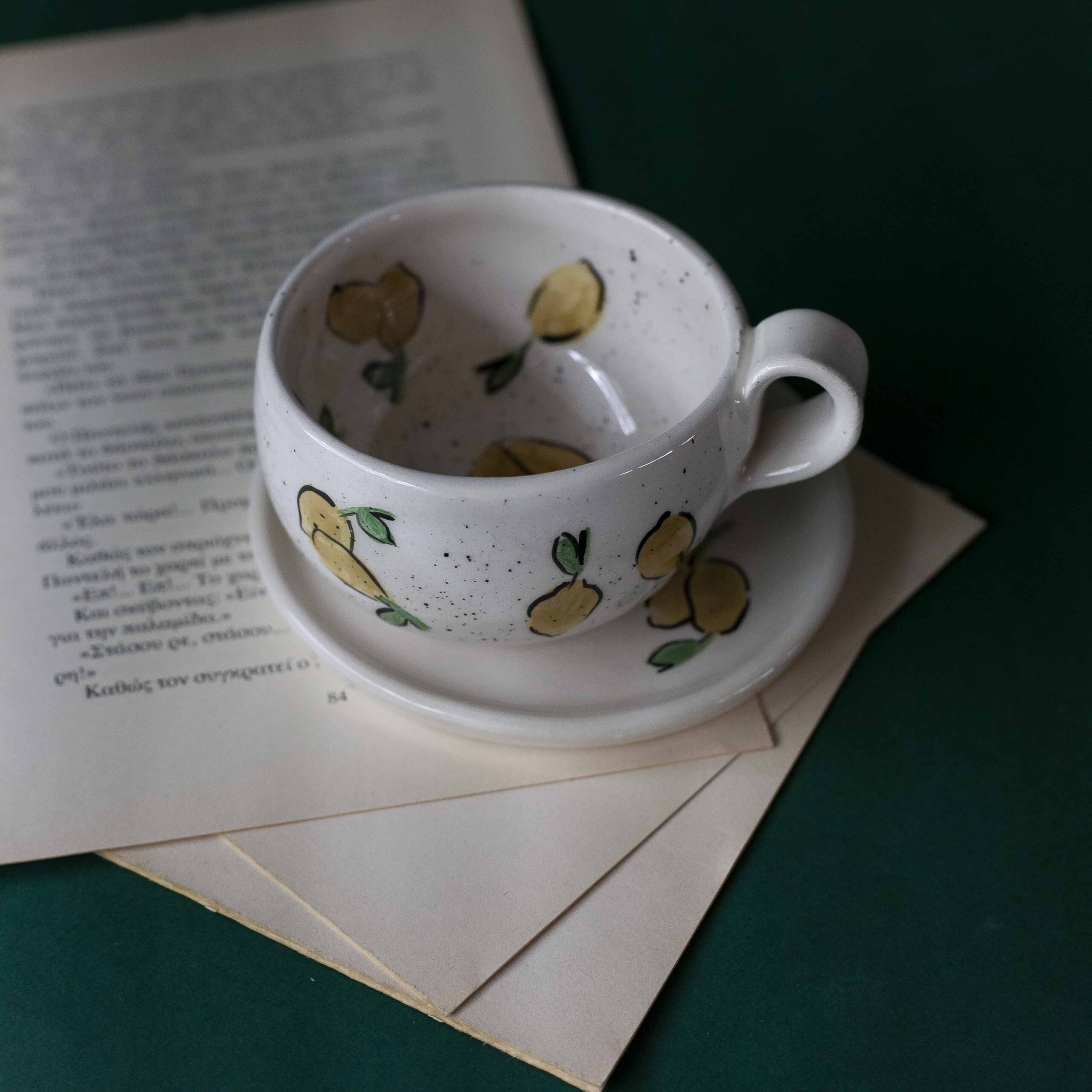 Χειροποίητα κεραμικά εσπρέσο κουπάκια με πιατάκι, διακοσμημένα με ζωγραφιστά φρουτάκια — πορτοκάλια, λεμόνια και αχλάδια — ανάμεσα σε μικρά λουλουδάκια. Οι δίχρωμοι συνδυασμοί και οι λεπτομέρειες στο χέρι χαρίζουν παιχνιδιάρικη και ζωντανή αισθητική. Κάθε σετ είναι μοναδικό, πλασμένο και ζωγραφισμένο στο χέρι, ιδανικό για να προσθέσει χρώμα και τέχνη σε κάθε στιγμή καφέ. Handmade ceramic espresso cup and saucer set, decorated with hand-painted fruits — oranges, lemons, and pears — surrounded by small flowers. The two-tone color combinations and fine hand-painted details give a lively, playful feel. Each set is one of a kind, crafted and painted by hand, perfect for adding a splash of color and artistry to your coffee moments.