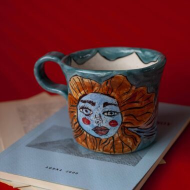 Χειροποίητη κεραμική κούπα διακοσμημένη με ζωγραφιστές μαργαρίτες και πολύχρωμα λουλούδια, όλα με γλυκά προσωπάκια και εκφραστικά μάτια. Πλασμένη και ζωγραφισμένη στο χέρι, κάθε κούπα είναι ένα μοναδικό έργο τέχνης που συνδυάζει τη φρεσκάδα της φύσης με μια παιχνιδιάρικη, ονειρική αισθητική. Ιδανική για όσους αγαπούν τα λουλούδια και τη χειροποίητη δημιουργία. Handmade ceramic mug decorated with painted daisies and colorful flowers, each featuring cute little faces with expressive eyes. Hand-shaped and hand-painted, every mug is a one-of-a-kind piece of art that blends the freshness of nature with a playful, dreamy aesthetic. Perfect for flower lovers and fans of handmade craftsmanship.