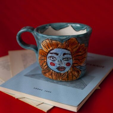 Χειροποίητη κεραμική κούπα διακοσμημένη με ζωγραφιστές μαργαρίτες και πολύχρωμα λουλούδια, όλα με γλυκά προσωπάκια και εκφραστικά μάτια. Πλασμένη και ζωγραφισμένη στο χέρι, κάθε κούπα είναι ένα μοναδικό έργο τέχνης που συνδυάζει τη φρεσκάδα της φύσης με μια παιχνιδιάρικη, ονειρική αισθητική. Ιδανική για όσους αγαπούν τα λουλούδια και τη χειροποίητη δημιουργία. Handmade ceramic mug decorated with painted daisies and colorful flowers, each featuring cute little faces with expressive eyes. Hand-shaped and hand-painted, every mug is a one-of-a-kind piece of art that blends the freshness of nature with a playful, dreamy aesthetic. Perfect for flower lovers and fans of handmade craftsmanship.