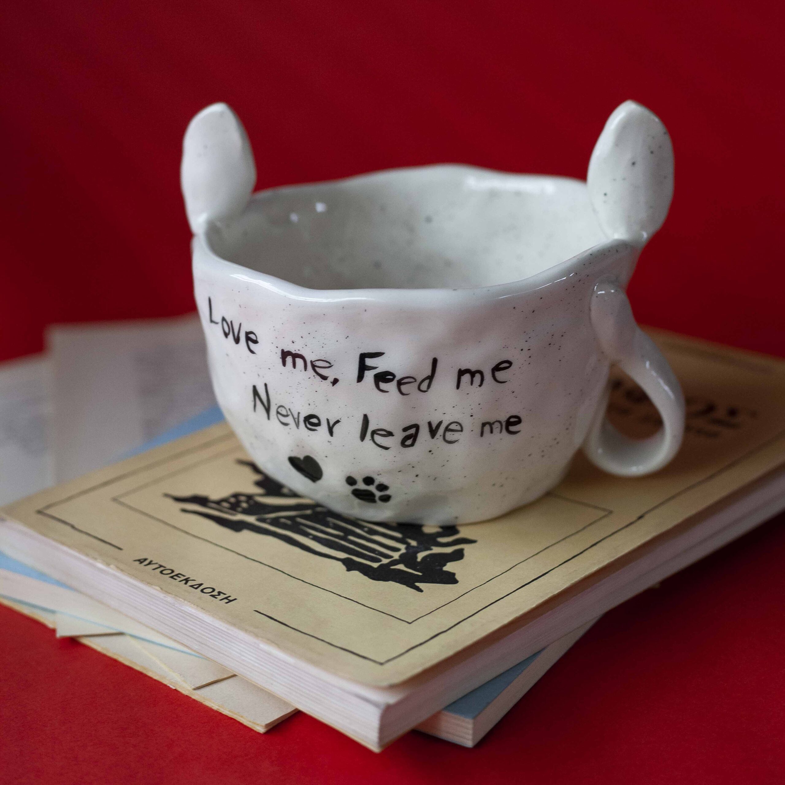 Χειροποίητα κεραμικά τασάκια και κούπες με σχέδια γατών, κάθε μία με ξεχωριστή έκφραση και χαρακτήρα. Πλασμένες και ζωγραφισμένες στο χέρι με ζωηρά χρώματα και καλλιτεχνικές λεπτομέρειες, ιδανικές για τους λάτρεις των γατών και της χειροποίητης τέχνης. Handmade ceramic cat-themed ashtrays and mugs, each featuring unique cat expressions and artistic charm. Hand-shaped and hand-painted with lively colors and creative details — perfect for cat lovers and fans of handmade artistry.