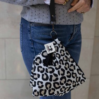 χειροποίητη τριγωνική τσαντούλα με δερμάτινο λουρί και κρεμαστή φούντα. Το μοτίβο της είναι λεοπάρ. handmade triangle bag with leather handle and tassels. the pattern is leopard.