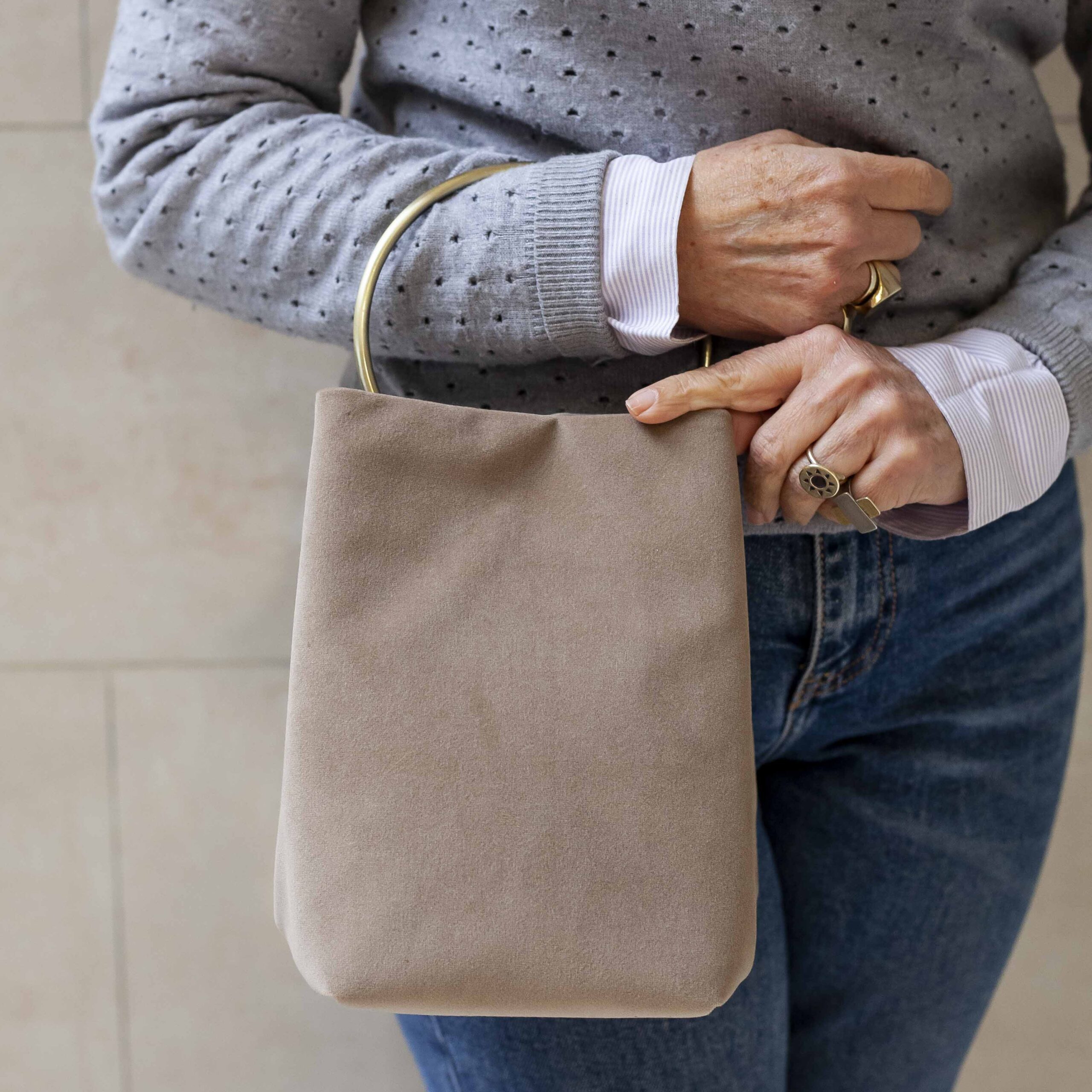 χειροποίητη βελούδινη μπεζ τσάντα με ένα μεγάλο χρυσό κρίκο για χερούλι. Handmade velvet beige bag with a big golden hoop as a handle.