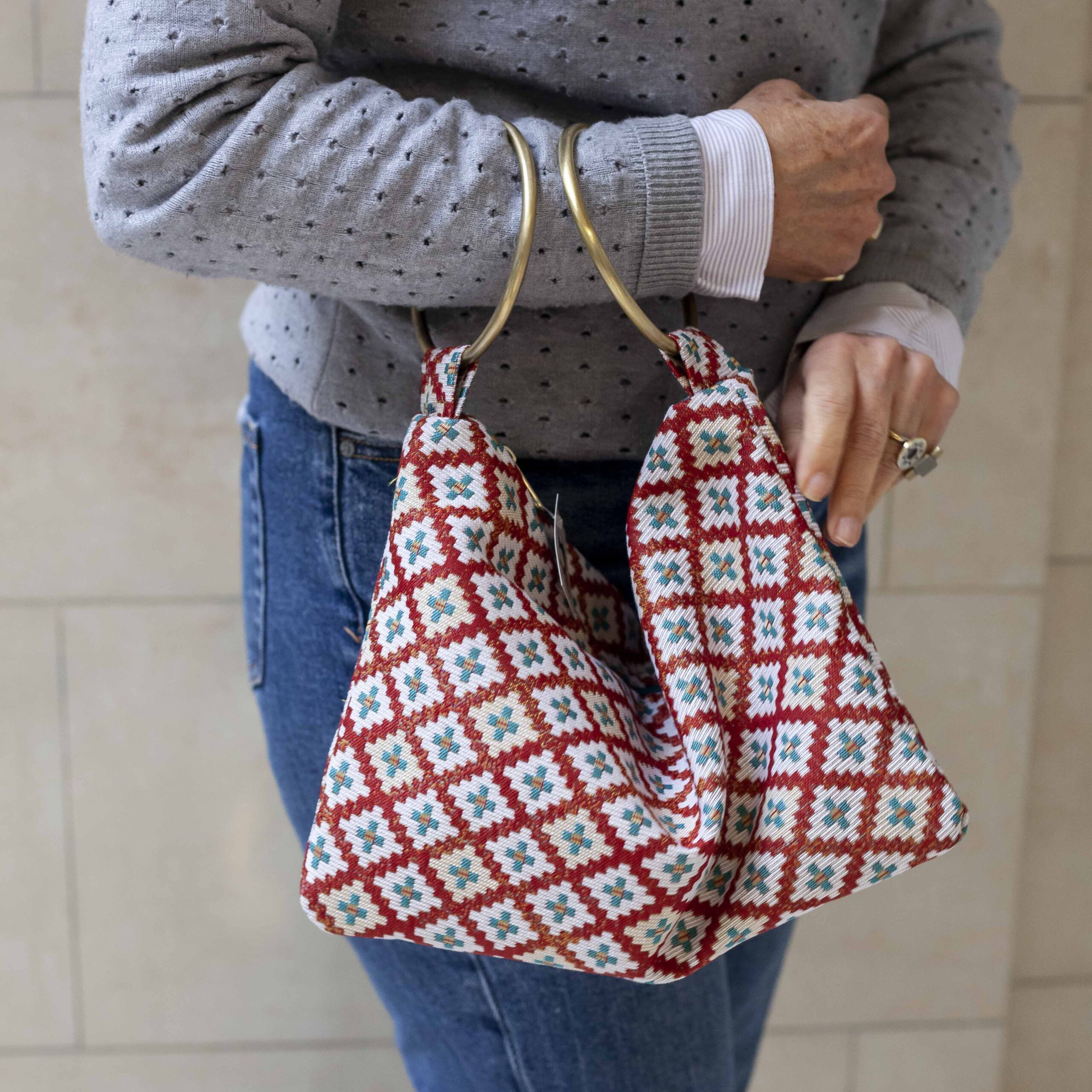 χειροποίητη τσάντα με δυο χρυσούς κρίκους για χερούλι σε τιρκουάζ και κόκκινα χρώματα. handmade bag with two golden hoops as handles in turquoise and red colors.