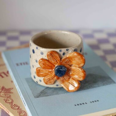 Handmade small ceramic mug with 3D flower handle in orange tones, beige speckled clay, unique pottery Μικρή χειροποίητη κεραμική κούπα με 3D λουλούδι που γίνεται χερούλι σε πορτοκαλί τόνους, μπεζ πηλός με σαμότ