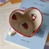 Large handmade heart-shaped ceramic mug with strawberries, beige speckled clay, cute aesthetic pottery Μεγάλη χειροποίητη κεραμική κούπα σε σχήμα καρδιάς με φράουλες, μπεζ πηλός με σαμότ
