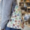 A handmade floral banana-style shoulder bag with a comfortable fit and secure zipper closure. Perfect for hands-free everyday wear with a touch of color. Χειροποίητο τσαντάκι ώμου τύπου μπανάνα με φλοράλ μοτίβο, άνετη εφαρμογή και ασφαλές κλείσιμο με φερμουάρ. Ιδανικό για καθημερινή χρήση με ελευθερία κινήσεων.