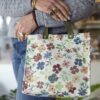 Handmade square floral bag with base, button closure and leather handles Χειροποίητο τετράγωνο φλοράλ τσαντάκι με πάτο, κούμπωμα με κουμπί και δερμάτινα χερούλια