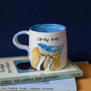 beautiful ceramic handmade mug with summer vibes. it has painted on sandy toes and sunkissed nose. χειροποίητη κεραμική κούπα που έχει πάνω ζωγραφισμένα πόδια που τα βρέχει η θάλασσα και ένα λουσμένο στον ήλιο πρόσωπο. επηρεασμένη από έντονα καλοκαιρινά vibes.
