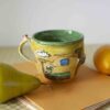 handmade ceramic mug with 3d elements. a mug from super mario game. in yellow shades. χειροποίητη κεραμική κούπα με 3ντι στοιχεία σε κίτρινους τόνους από το σούπερ μάριο.