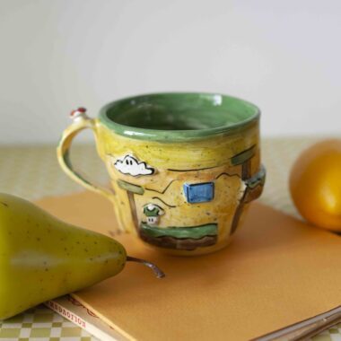 handmade ceramic mug with 3d elements. a mug from super mario game. in yellow shades. χειροποίητη κεραμική κούπα με 3ντι στοιχεία σε κίτρινους τόνους από το σούπερ μάριο.